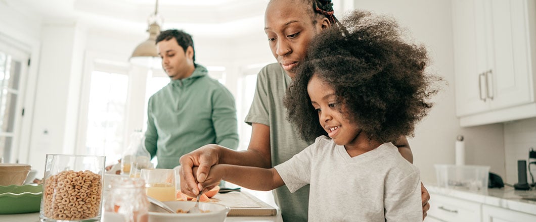 Mom guiding her daughter how to eat properly