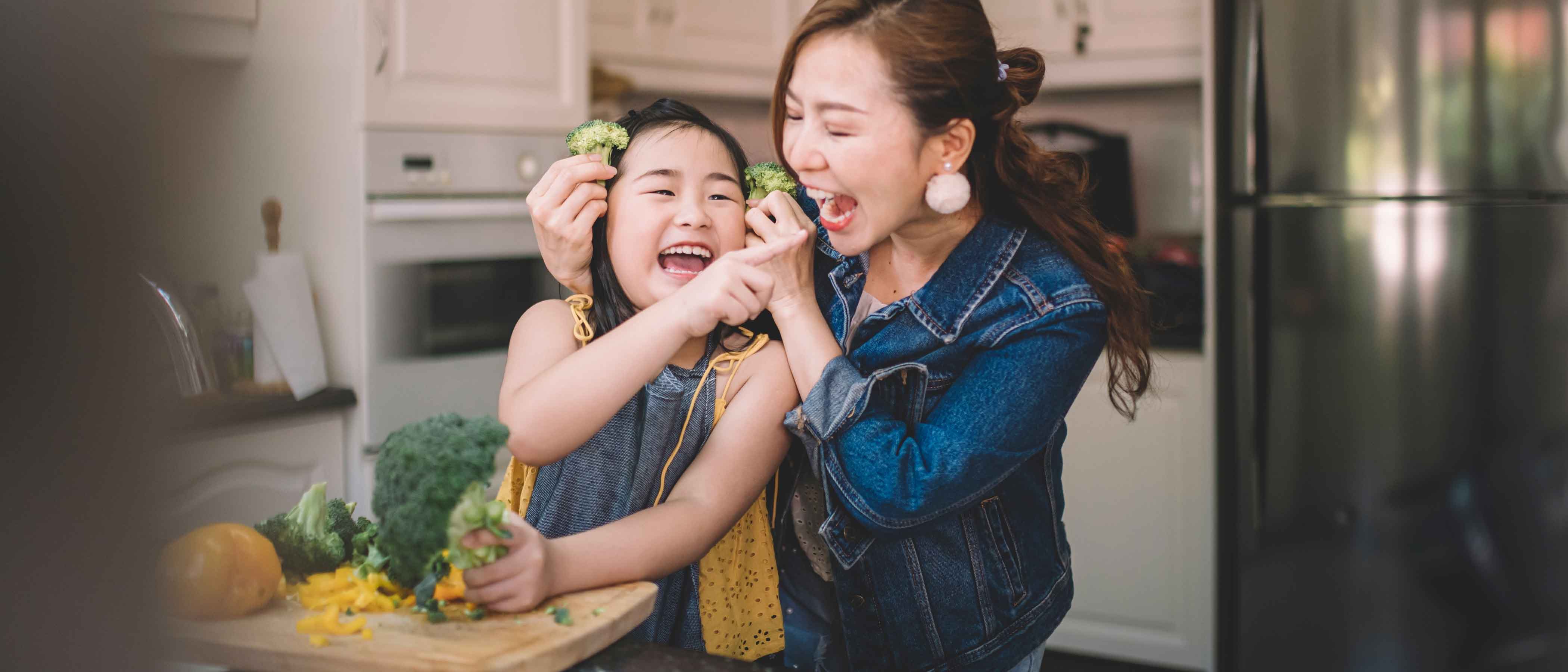 Mother and daughter in kitchen having fun while preparing food