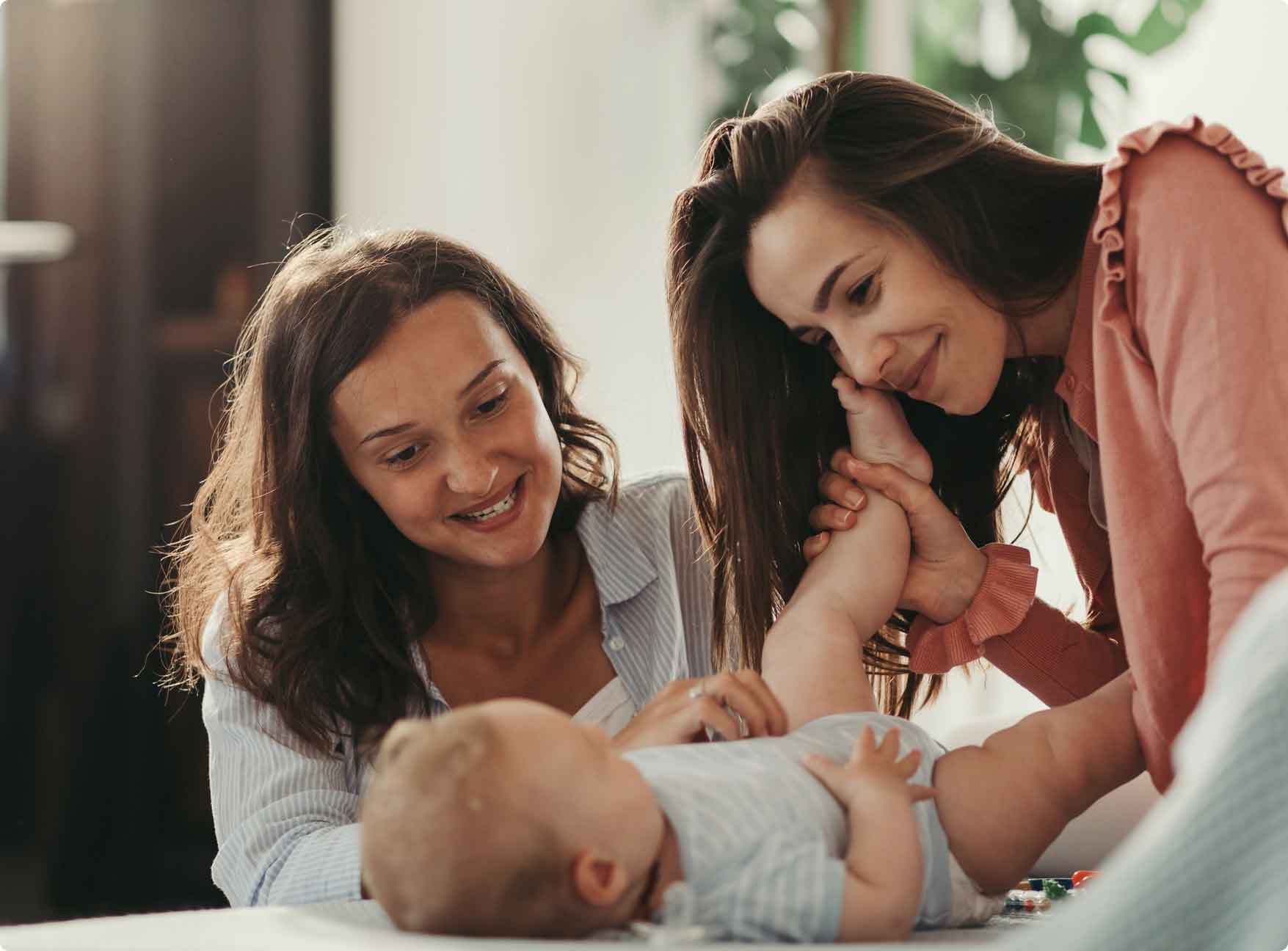 Mother holding baby's leg getting ready to change diaper