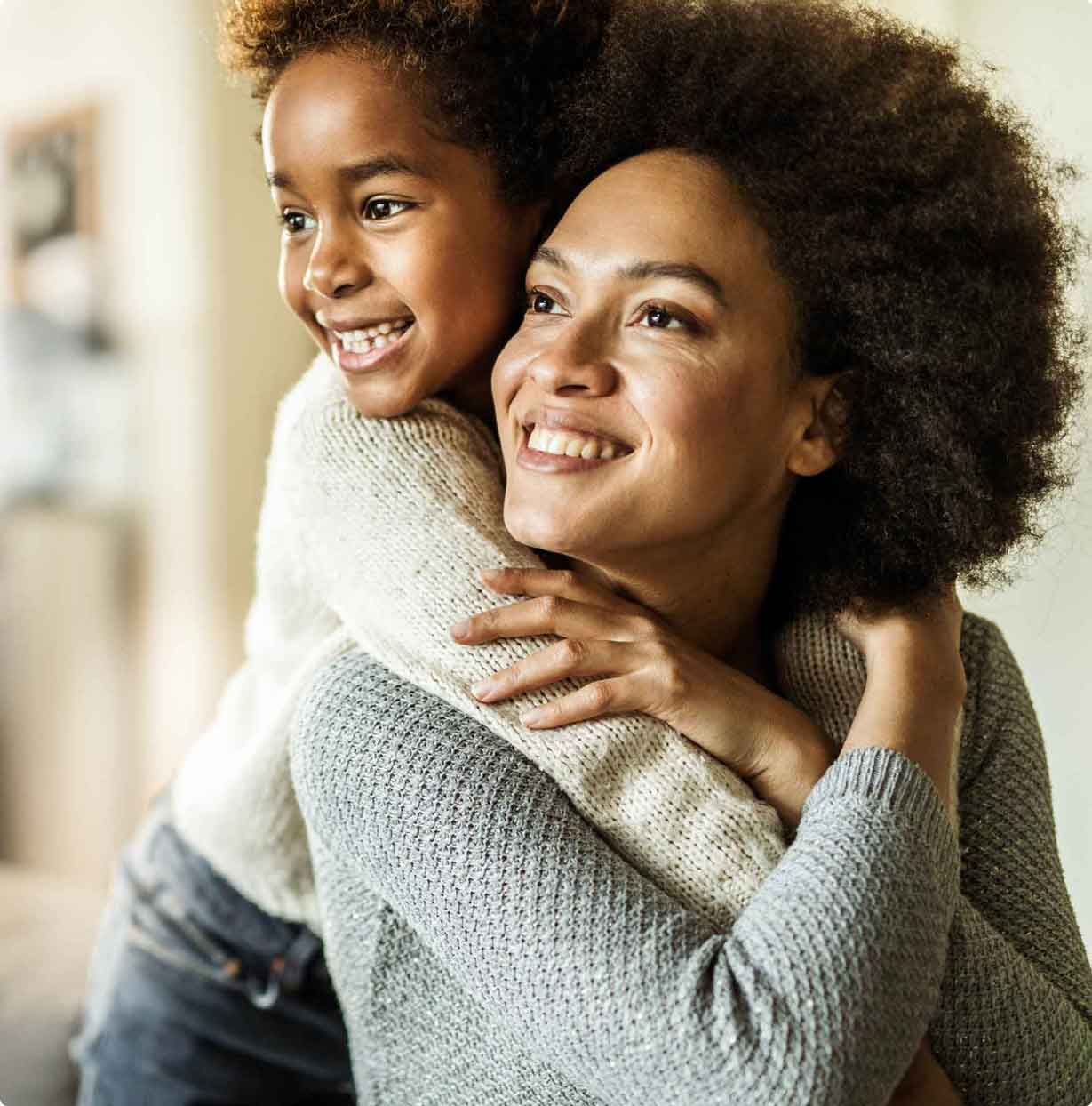 Affectionate African American mother and daughter embracing at home