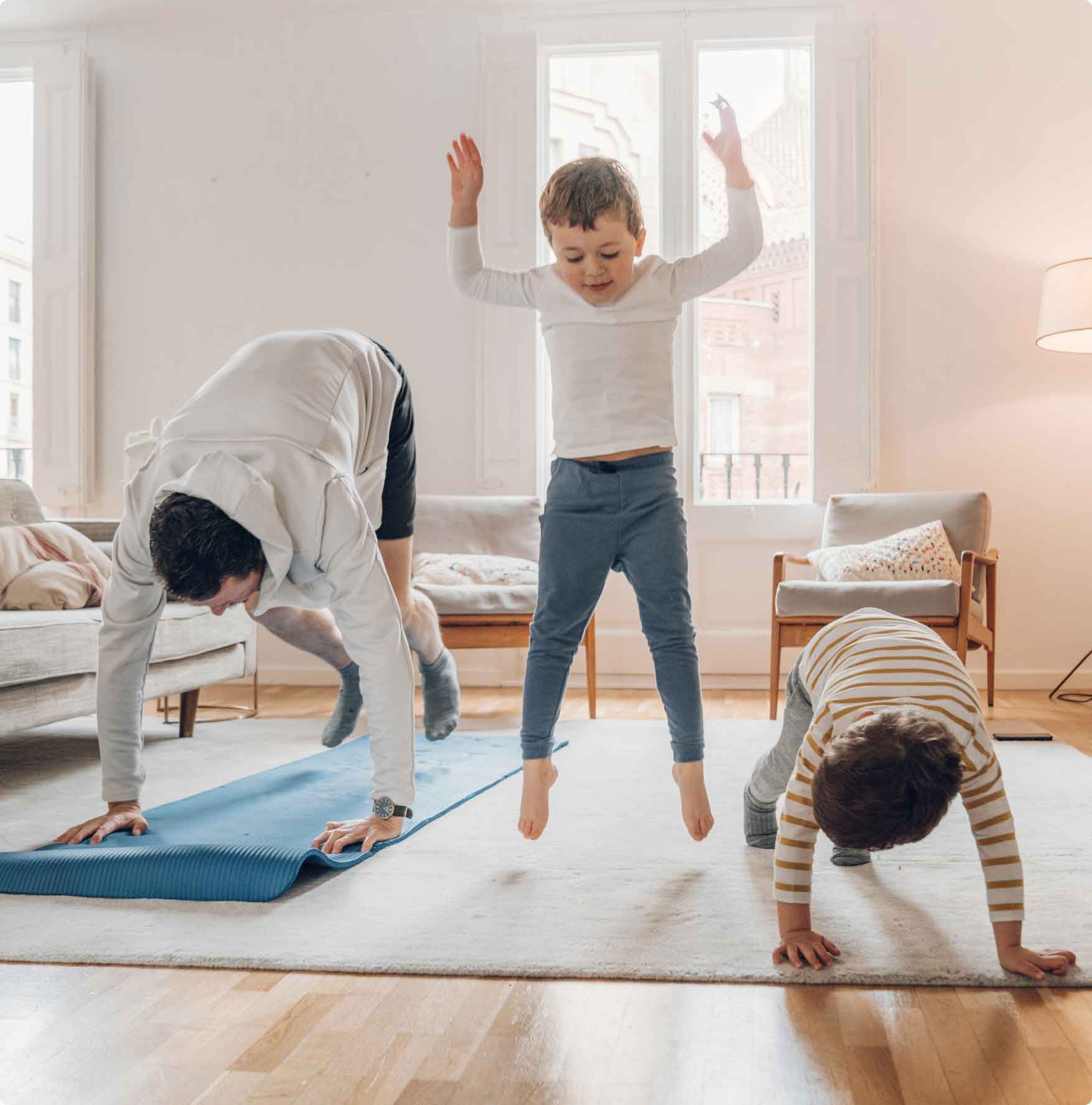 Father and sons exercising together in their living room